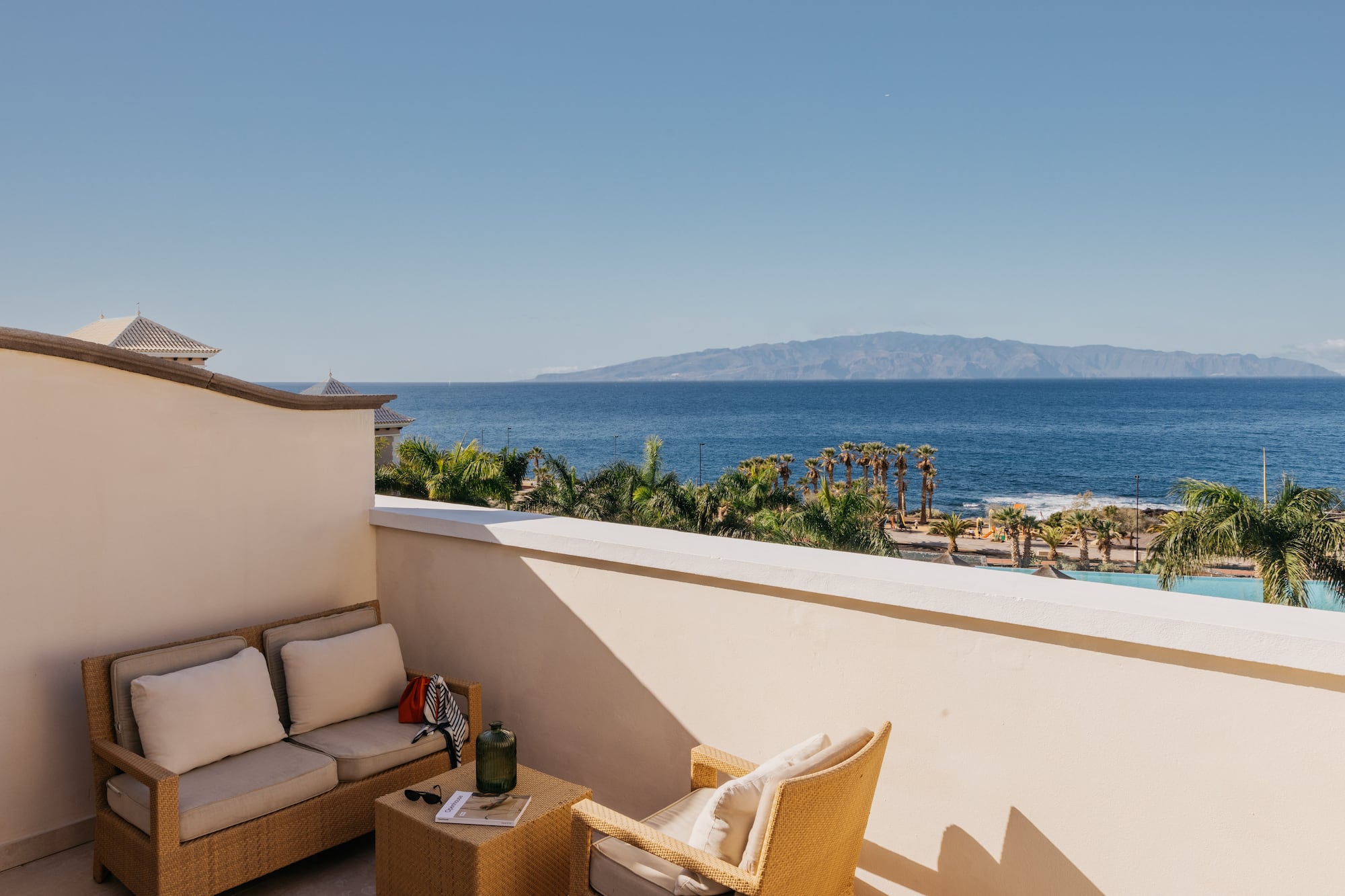 a balcony with a view of the ocean and a couch and a table