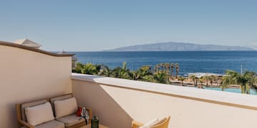 a balcony with a view of the ocean and a couch and a table