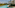 Long resort swimming pool, modern hotel with balconies, and lush palm trees.