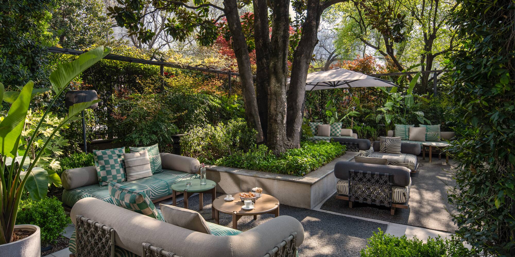 a patio with a tree and chairs