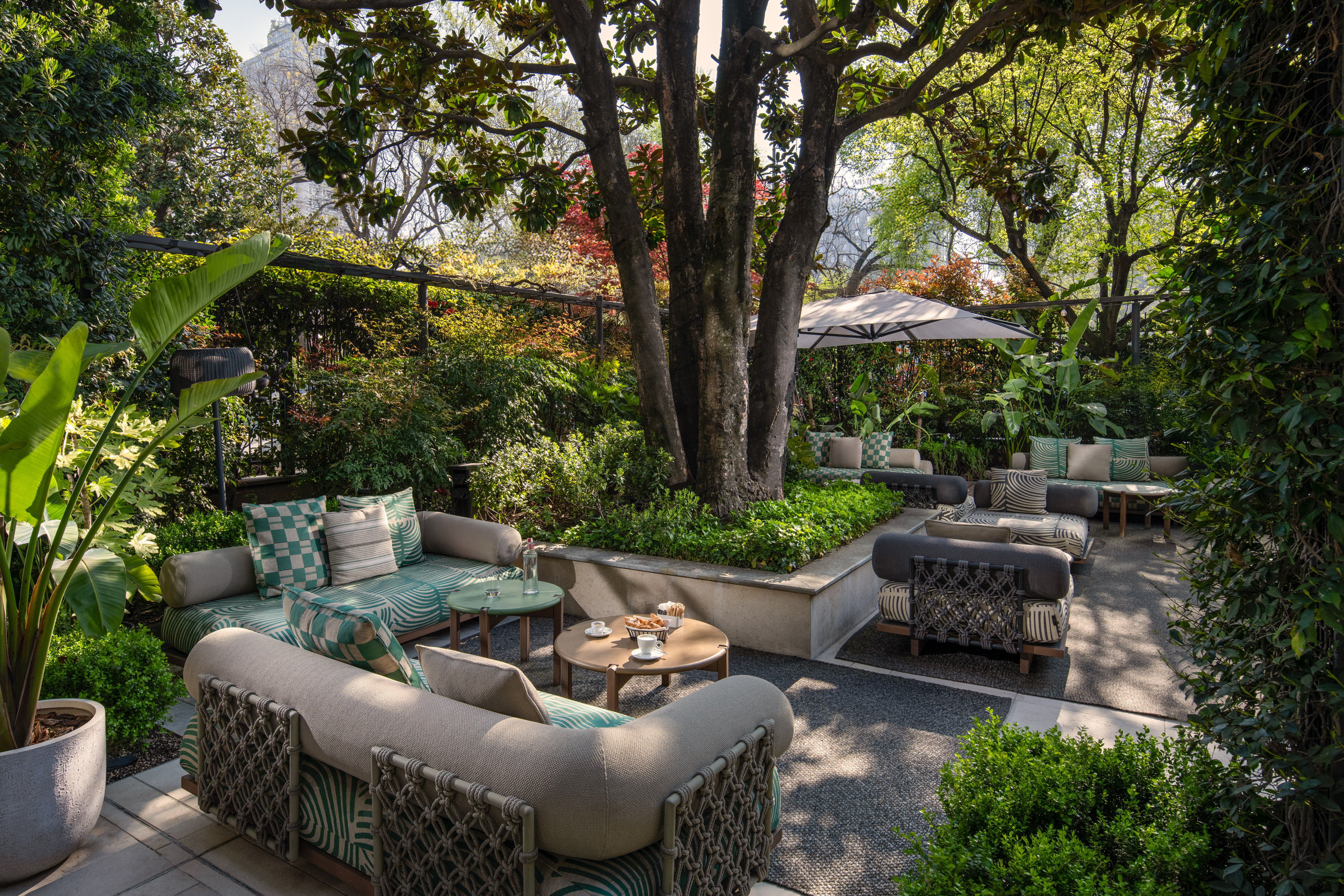 Lush garden patio with comfortable outdoor seating and coffee tables.