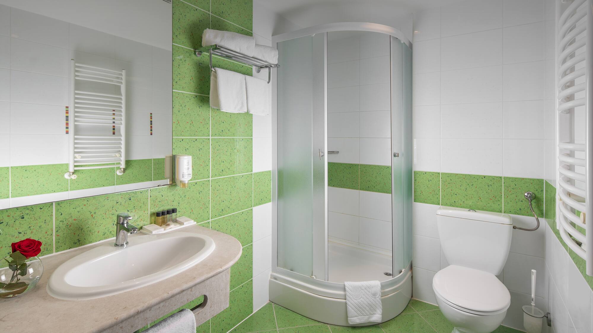 a bathroom with green tiles