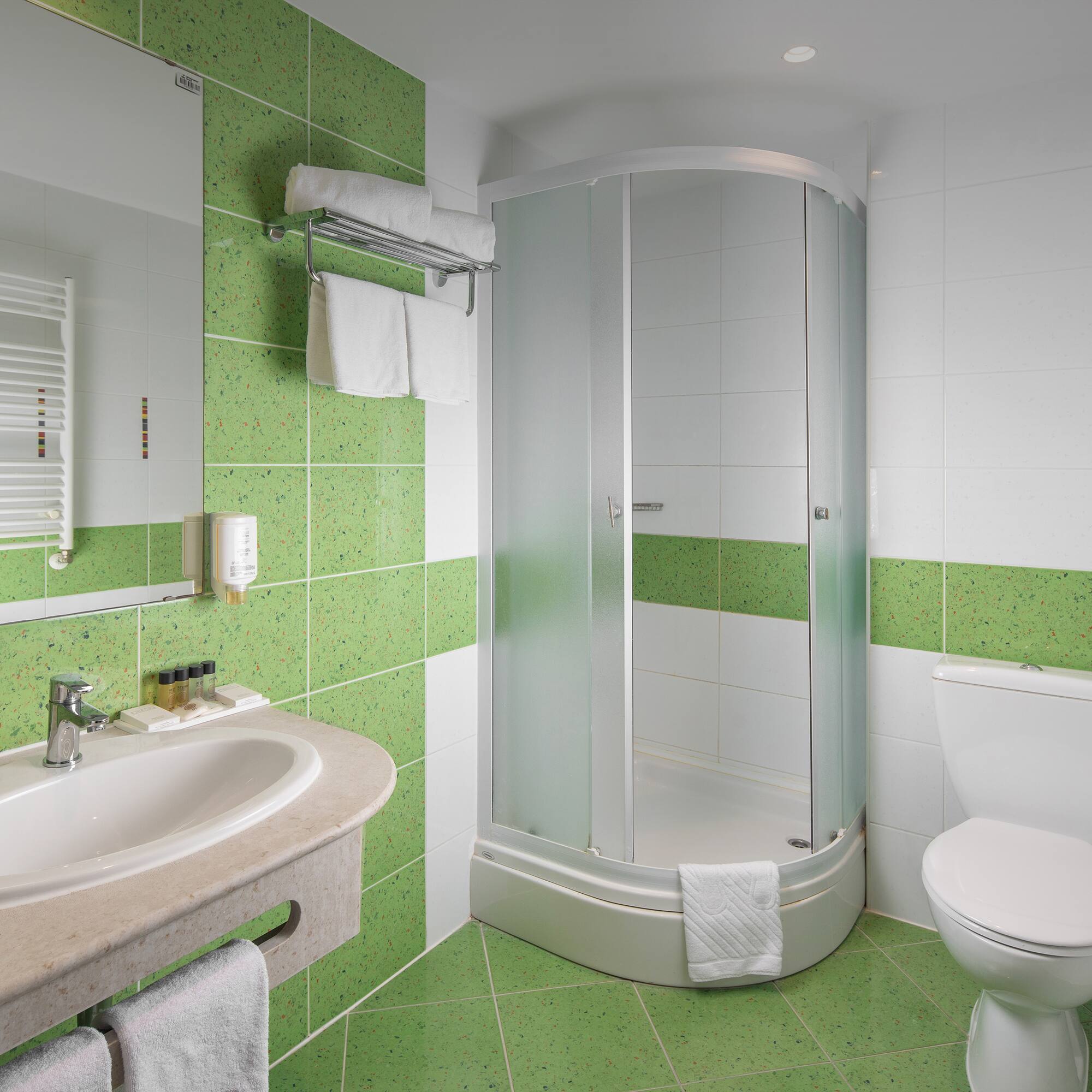 a bathroom with green tiles