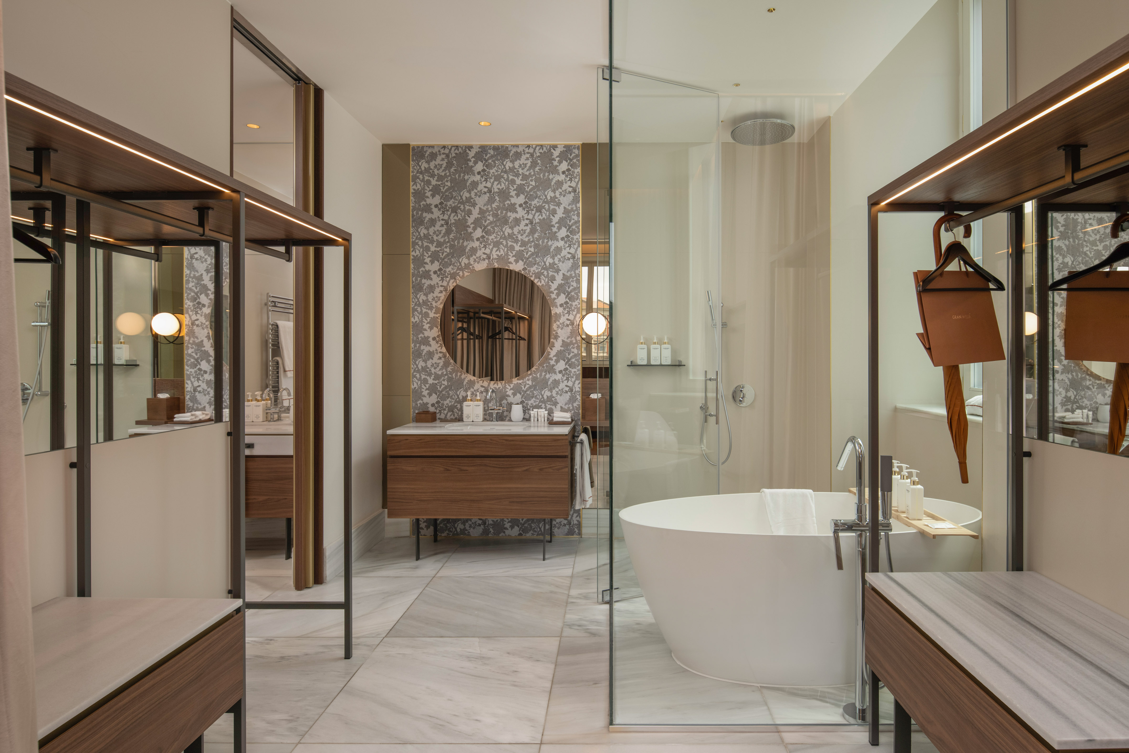 Modern luxury bathroom with freestanding tub, glass shower, and wood vanity.