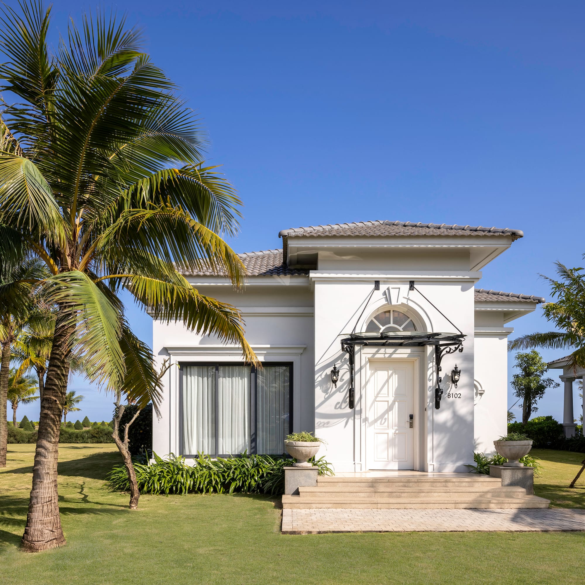 a white house with palm trees