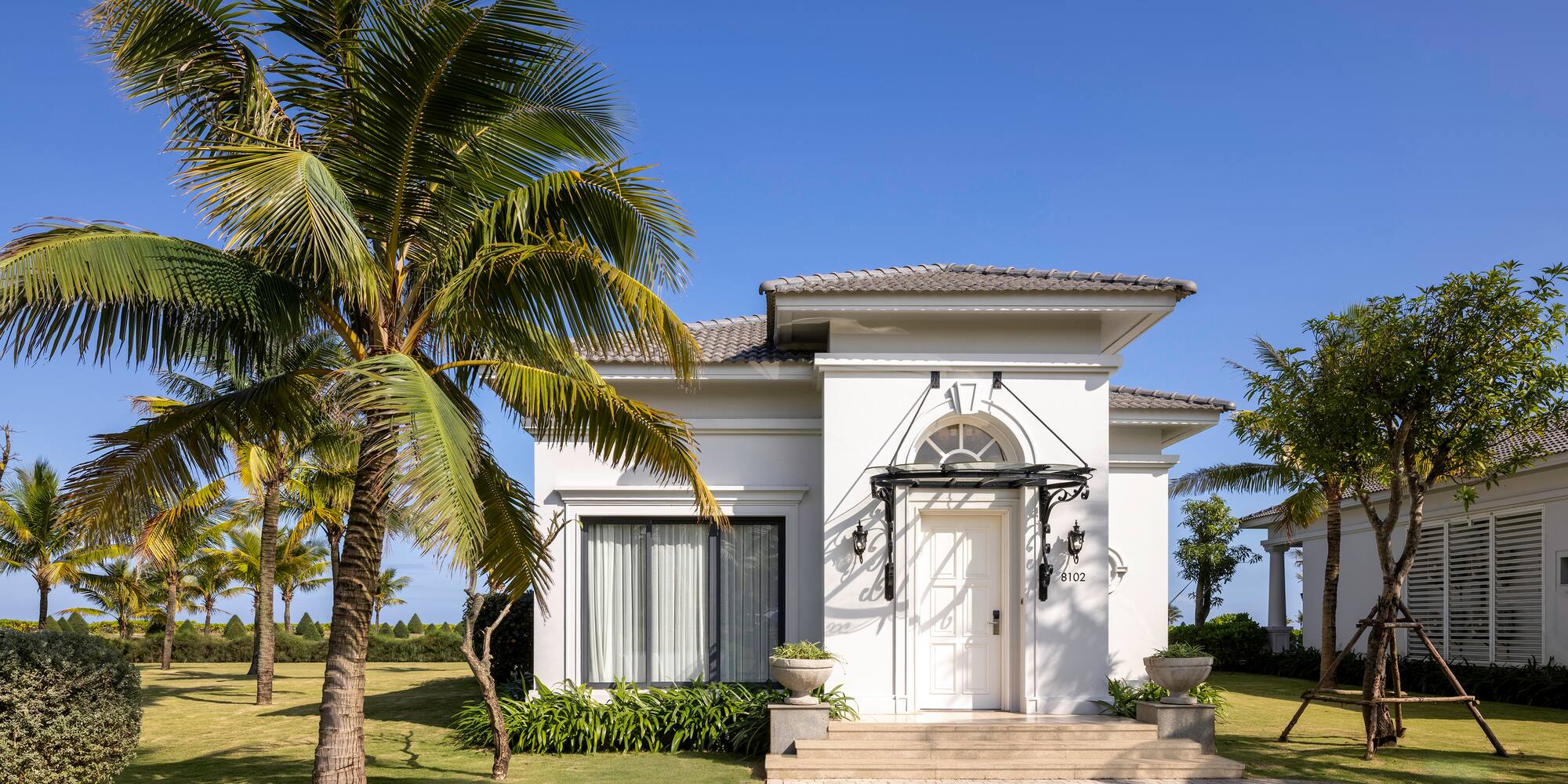 a white house with palm trees