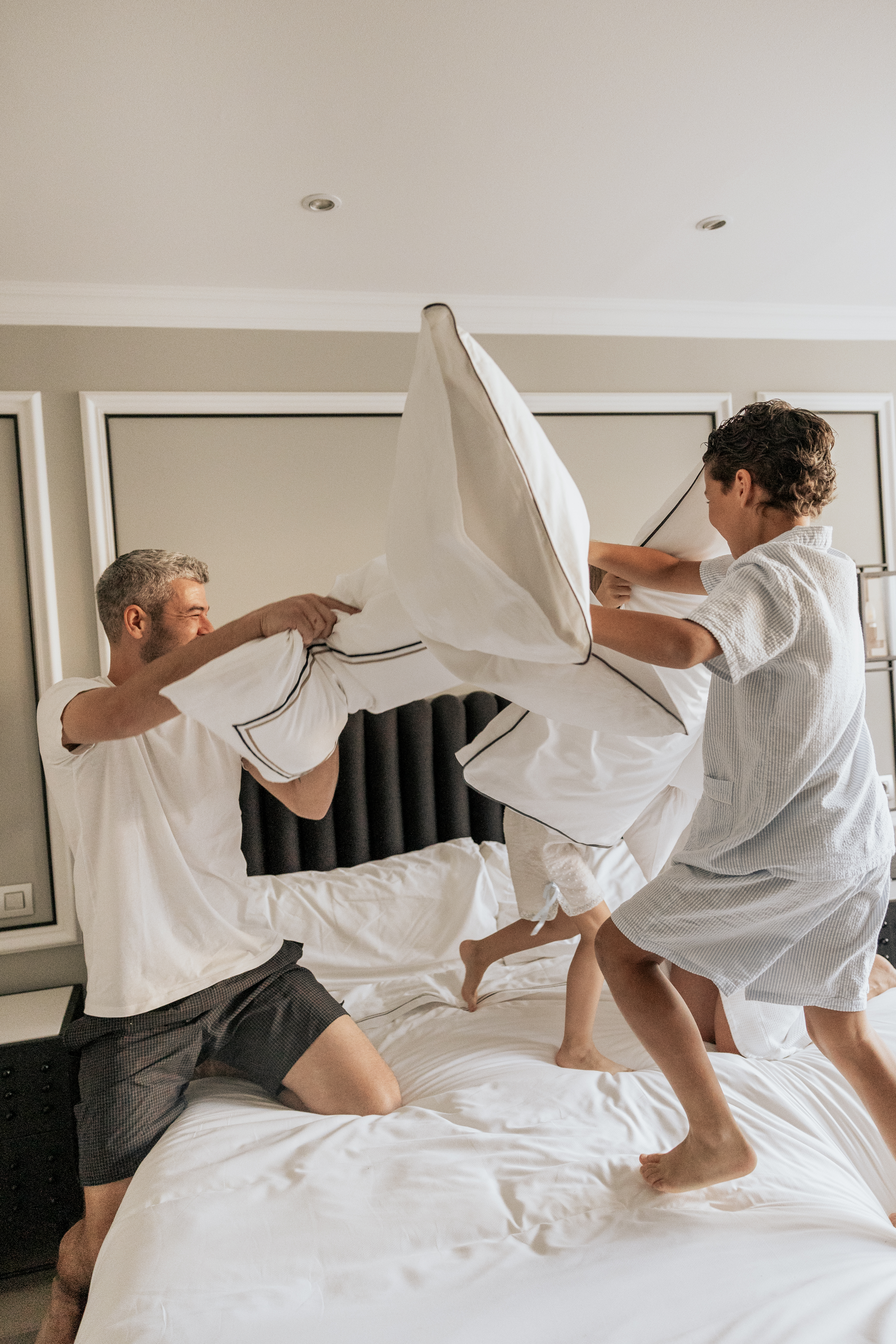 a group of people fighting pillows on a bed