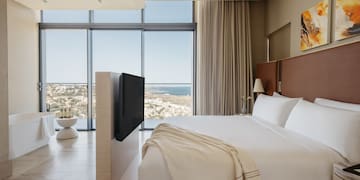 a bedroom with a large window overlooking the ocean