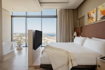 a bedroom with a large window overlooking the ocean