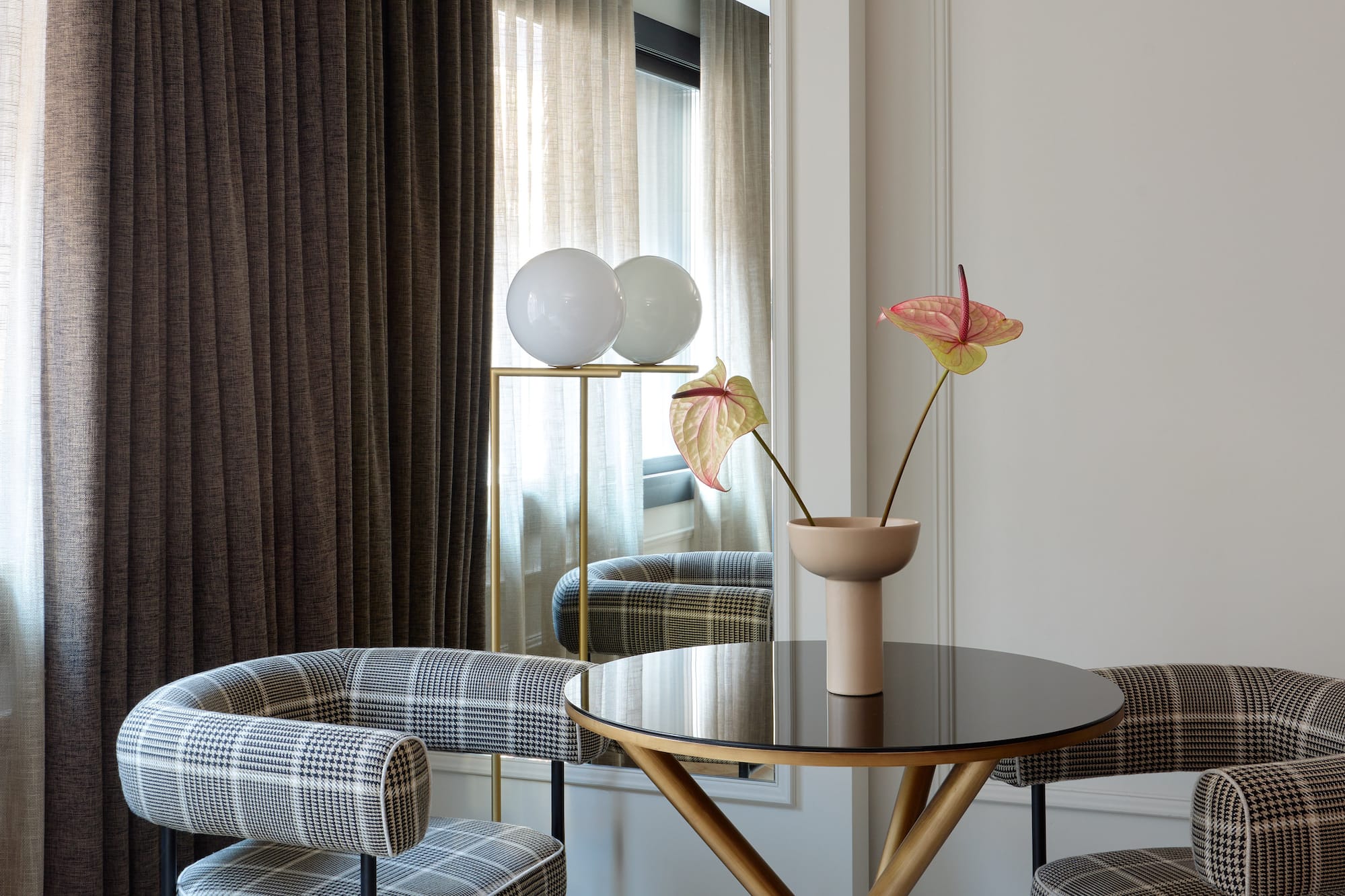 a table with chairs and a vase of flowers