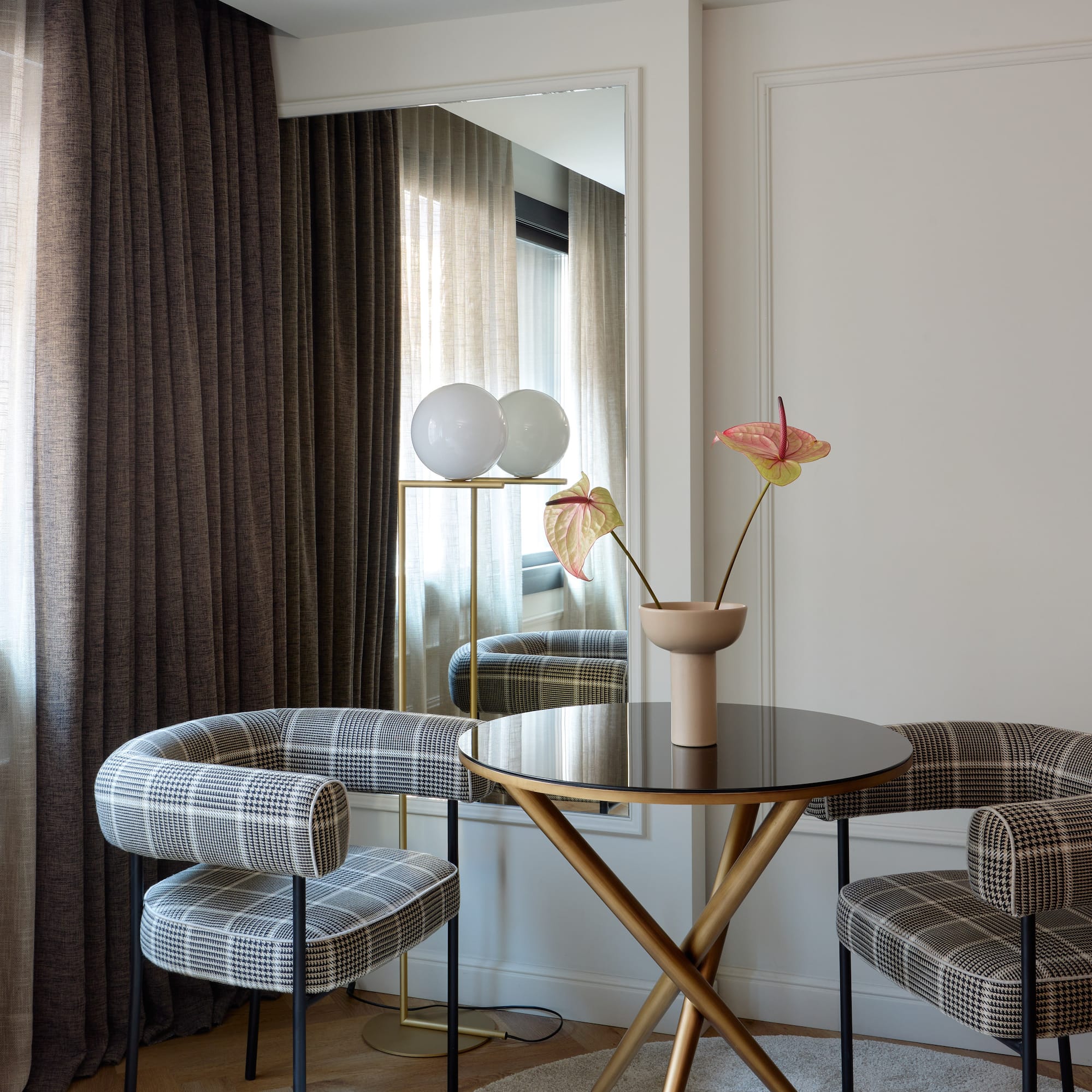 a table with chairs and a vase of flowers