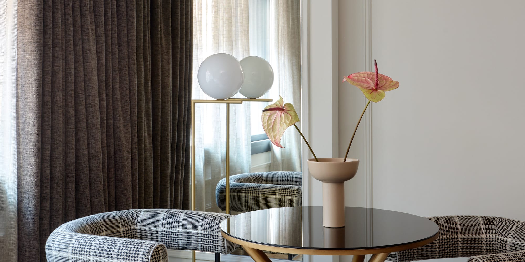 a table with chairs and a vase of flowers