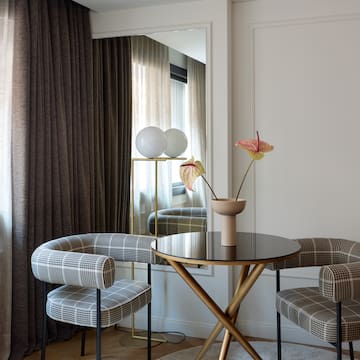 a table with chairs and a vase of flowers