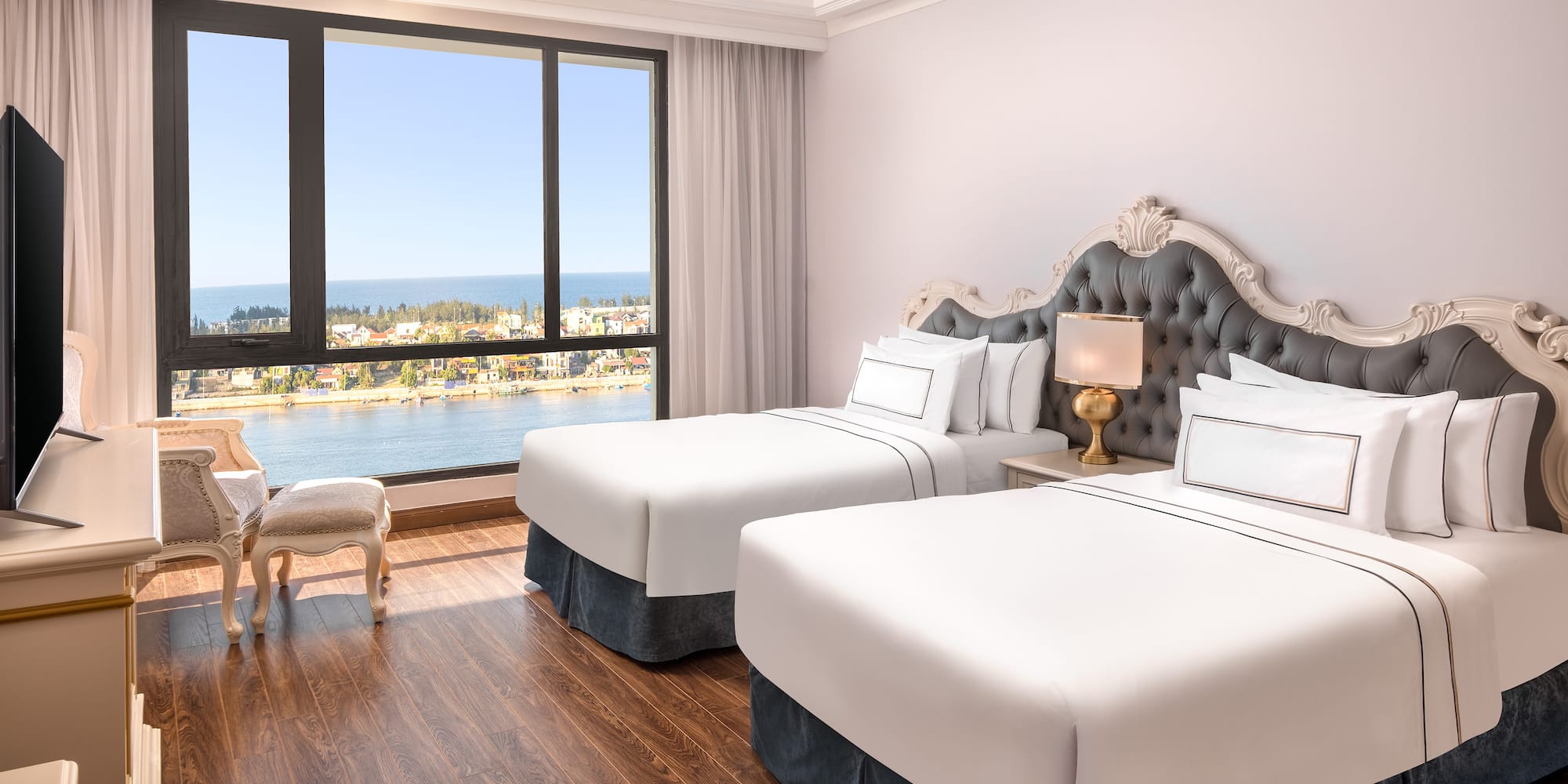 a room with two beds and a window overlooking the water