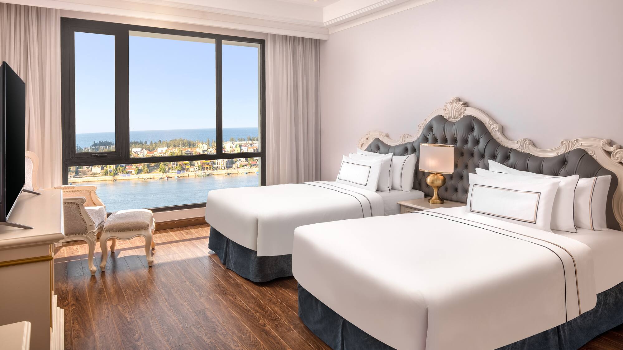 a room with two beds and a window overlooking the water