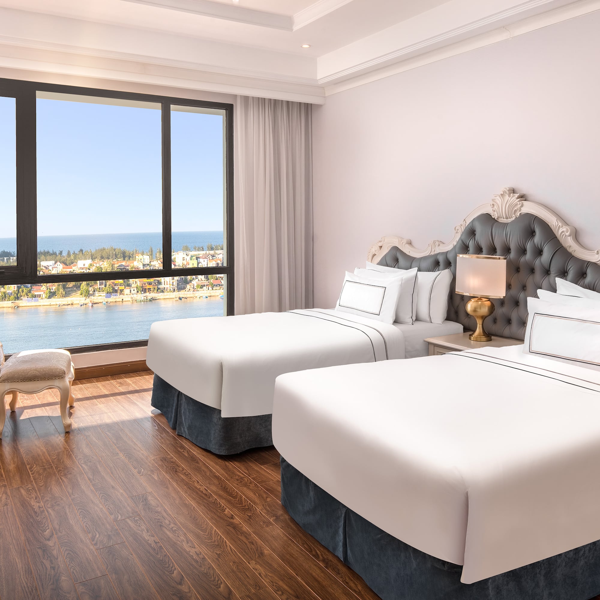 a room with two beds and a window overlooking the water