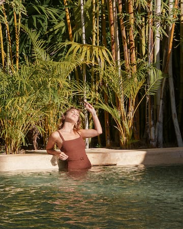 a man and woman sitting on a pool side