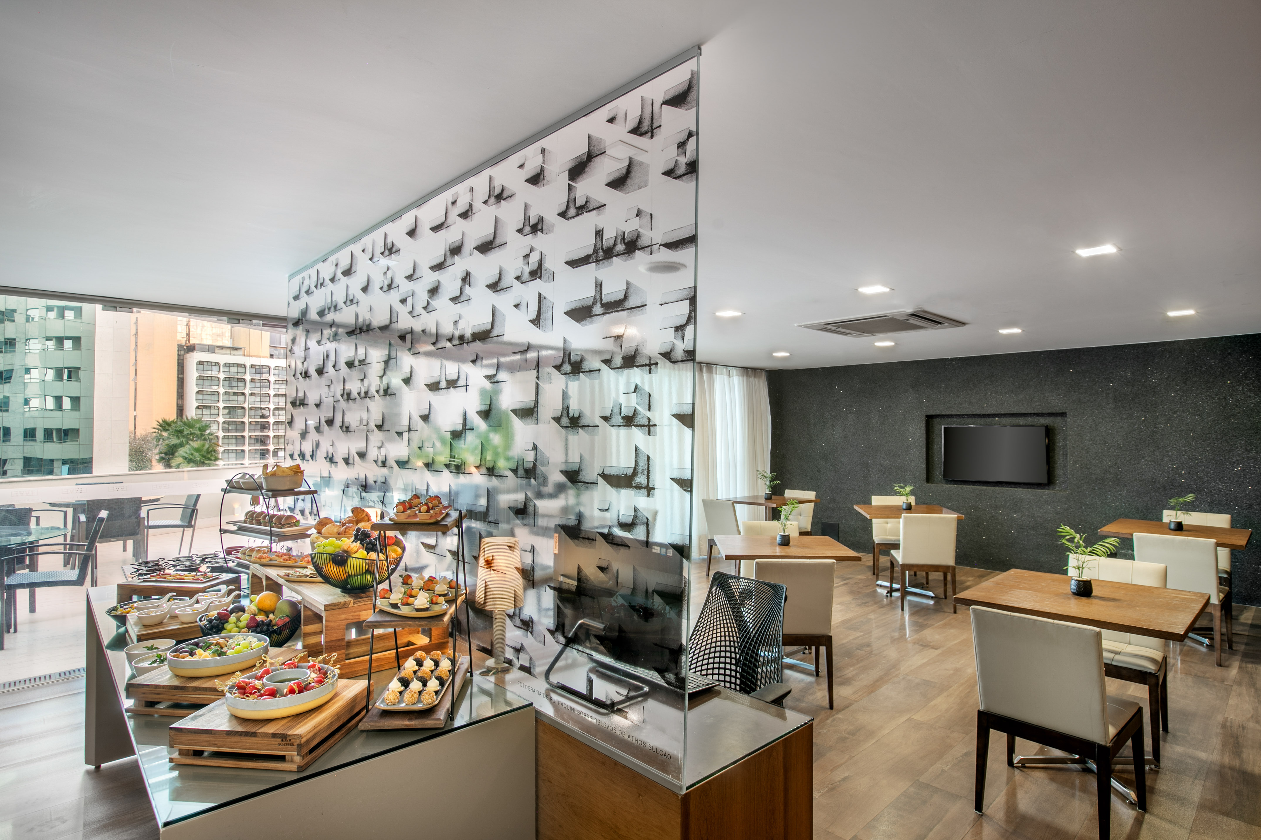 Modern hotel breakfast buffet with fresh food, dining area, and city view.