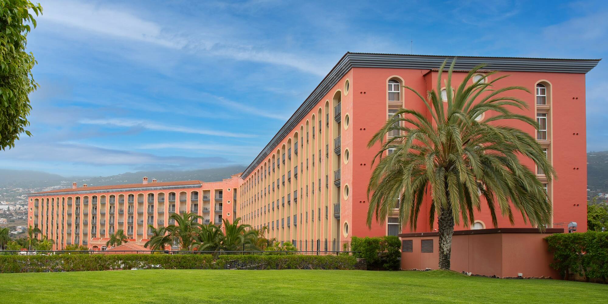 a large building with palm trees in front of it