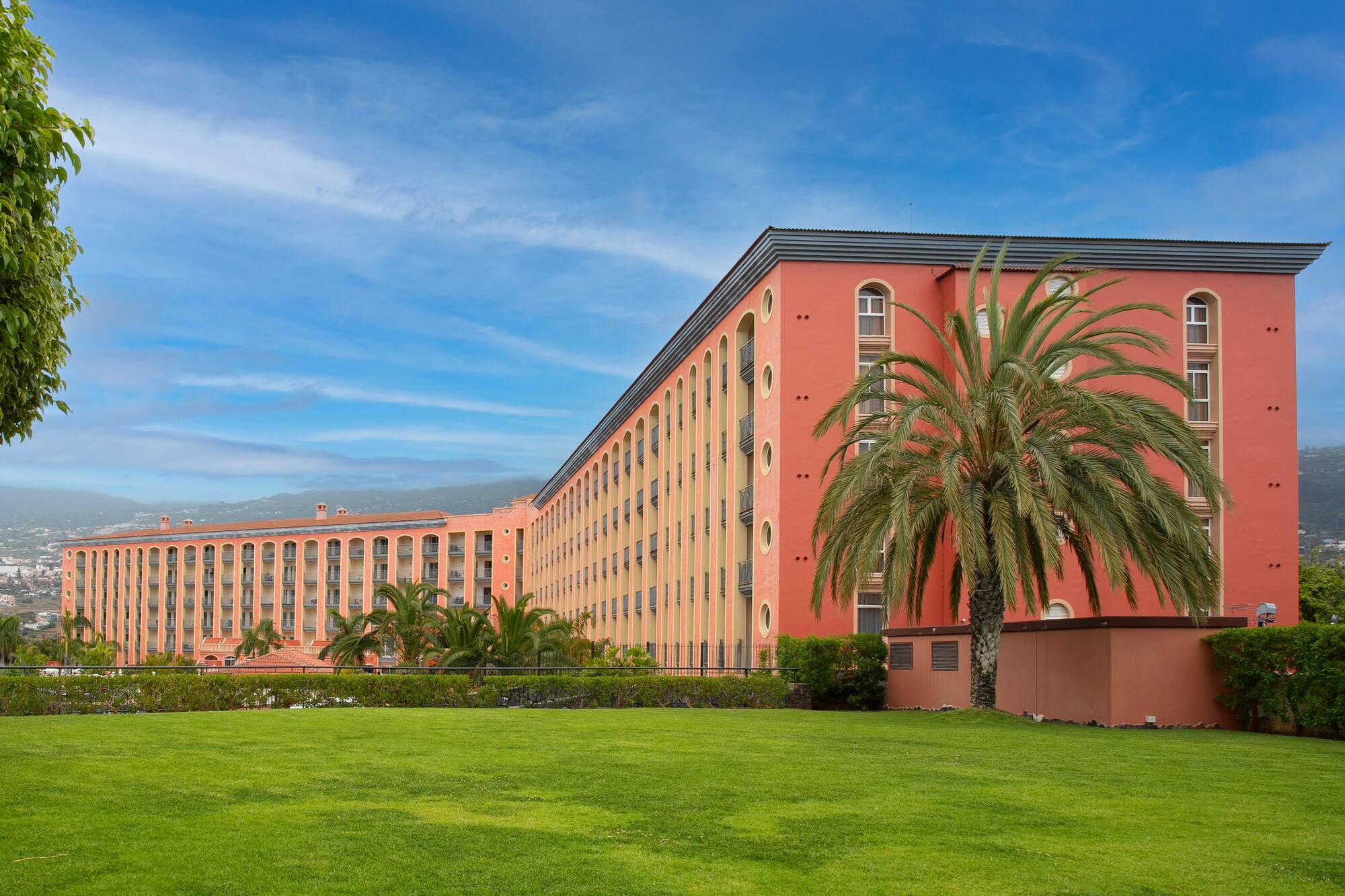 a large building with palm trees in front of it