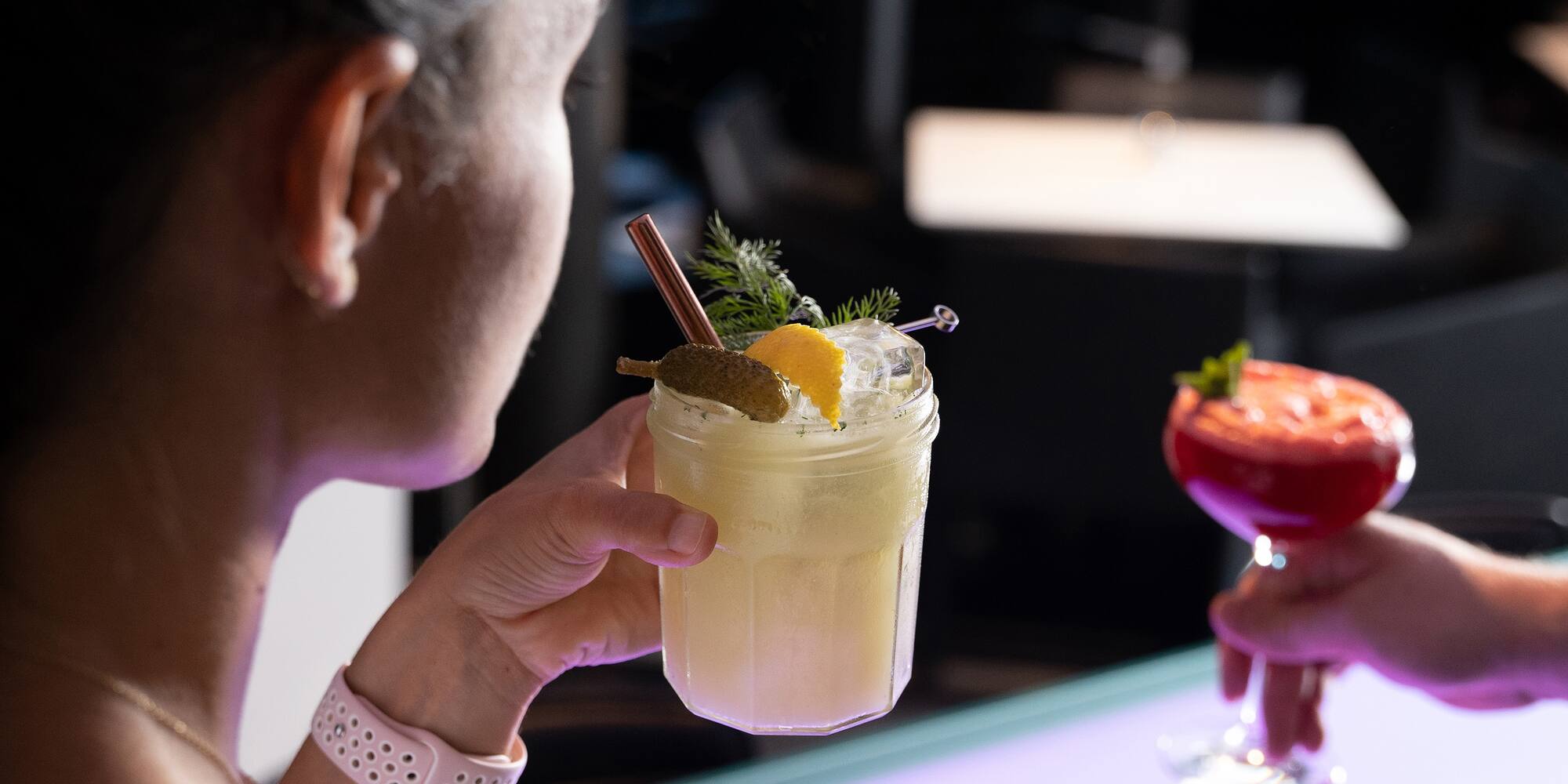 a woman holding a glass of drink