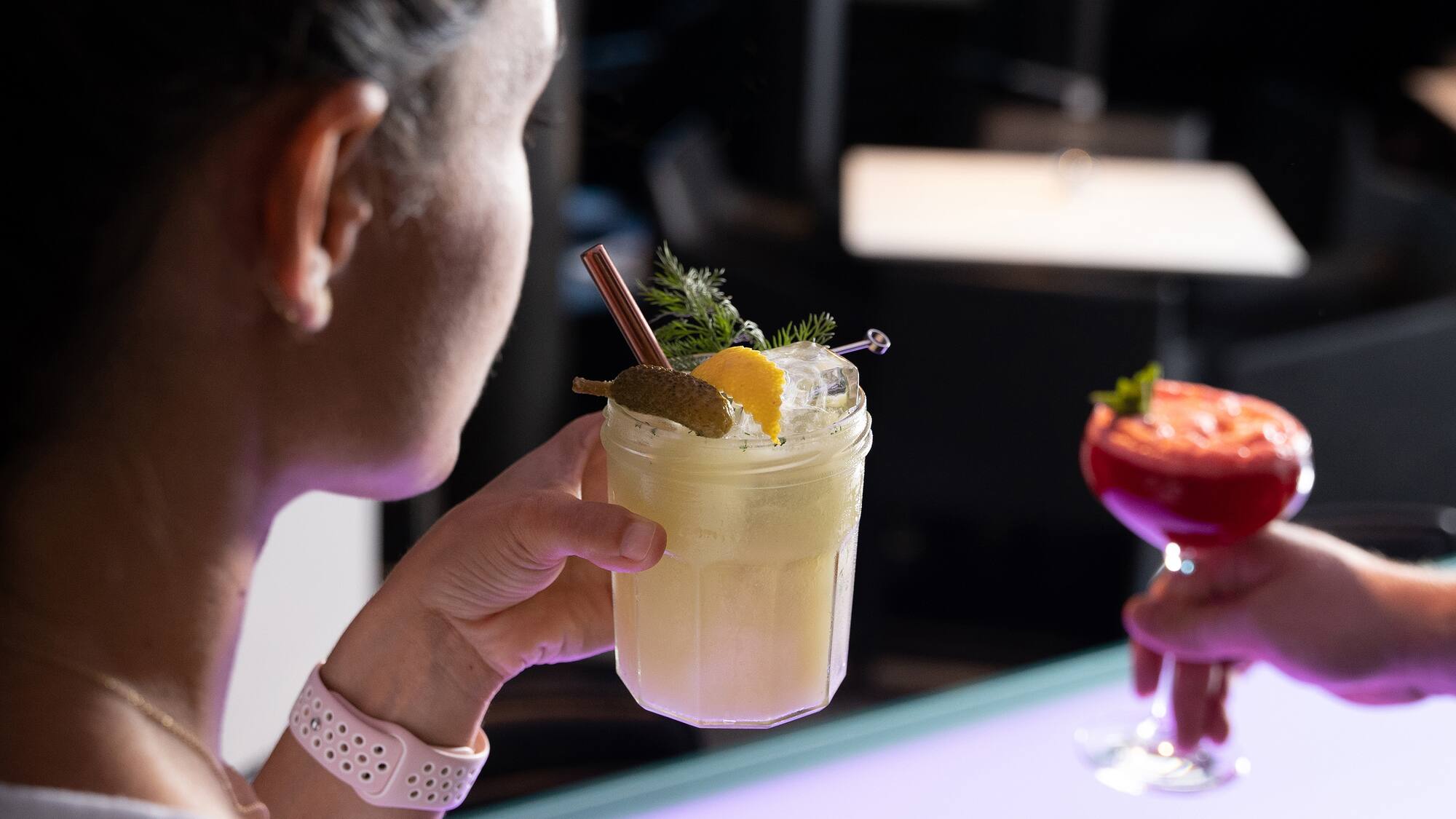 a woman holding a glass of drink