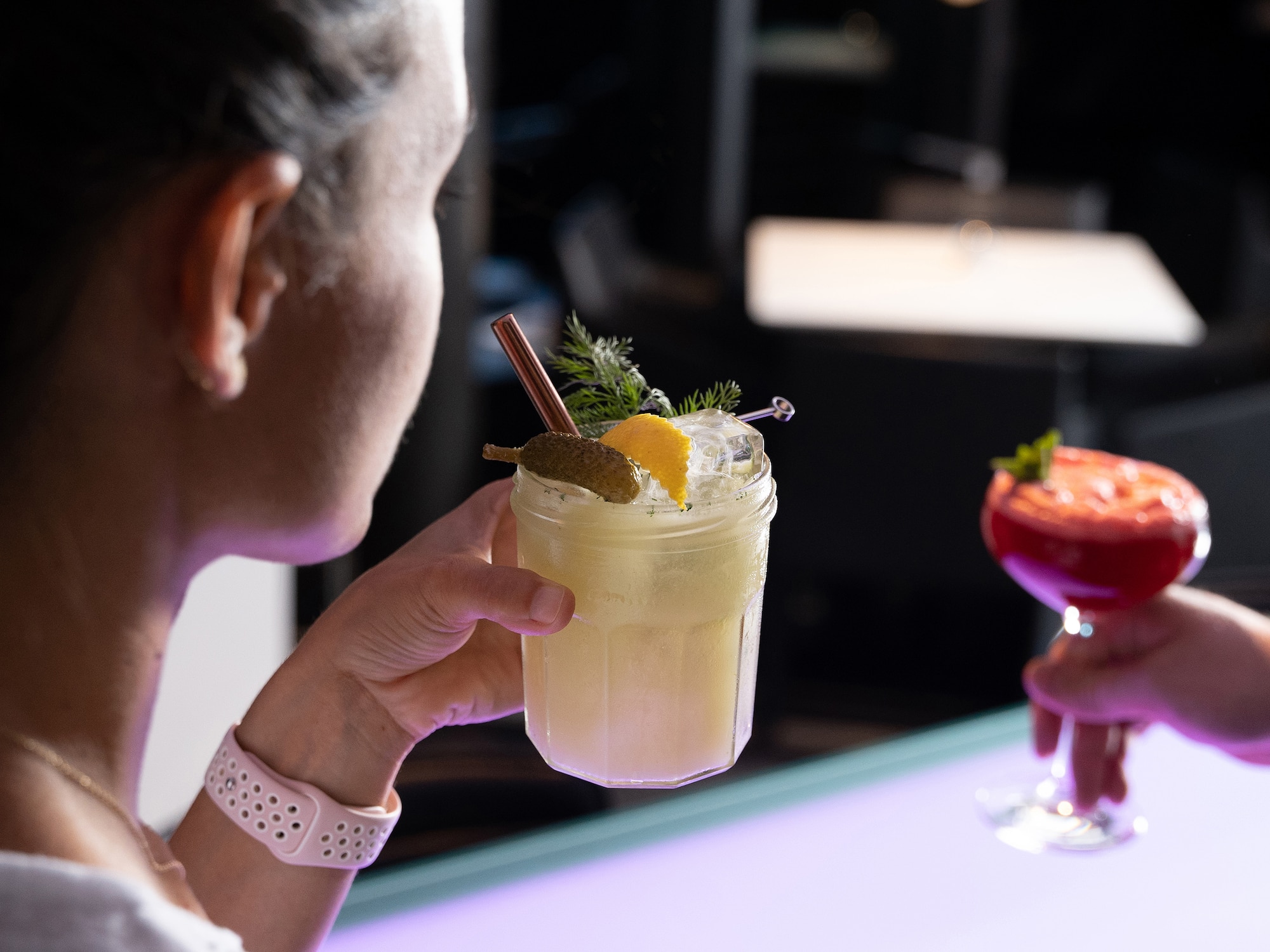 a woman holding a glass of drink