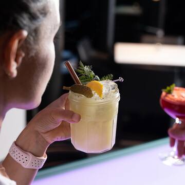 a woman holding a glass of drink
