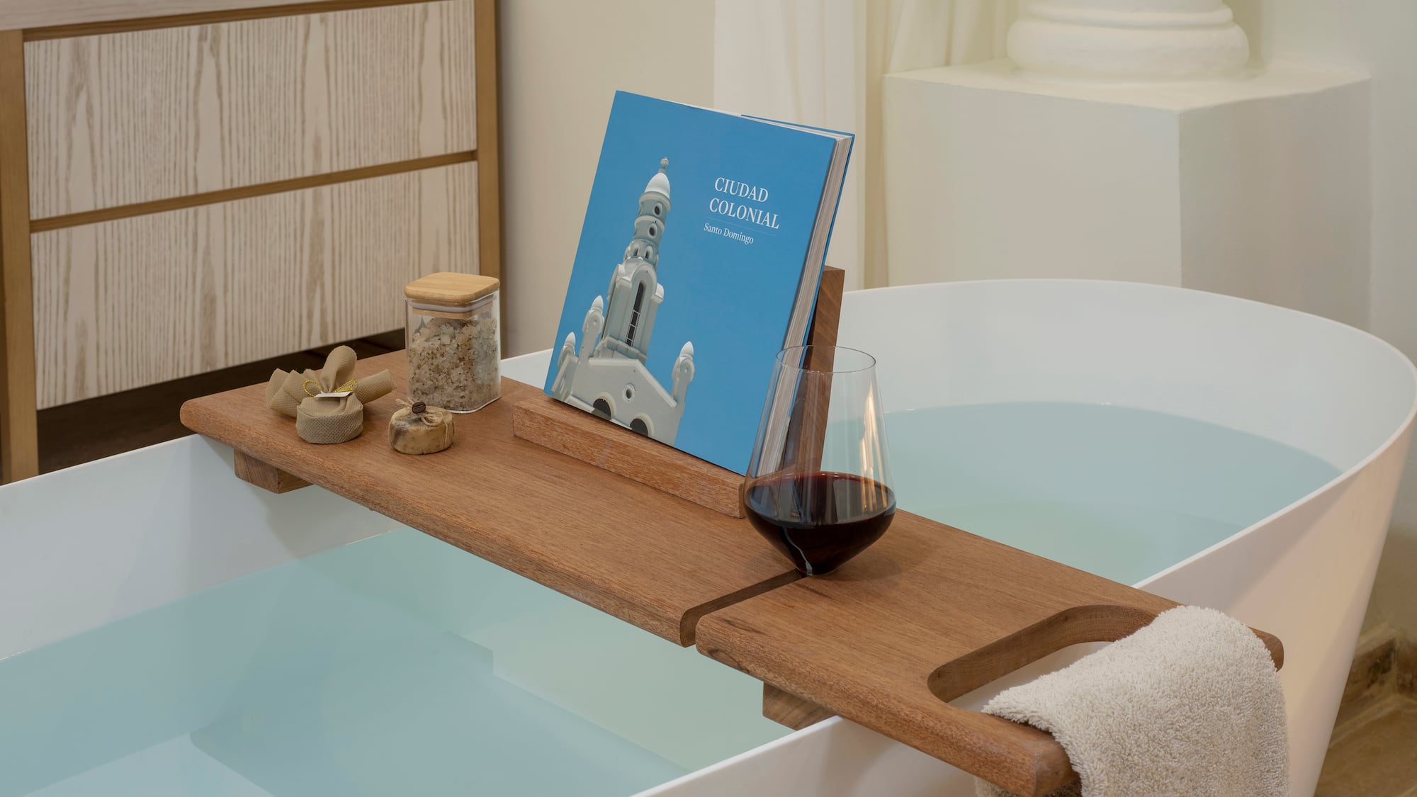 a bathtub with a book and a glass of wine