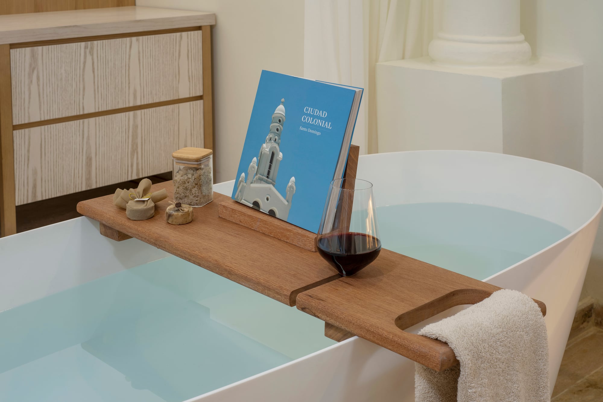 a bathtub with a book and a glass of wine