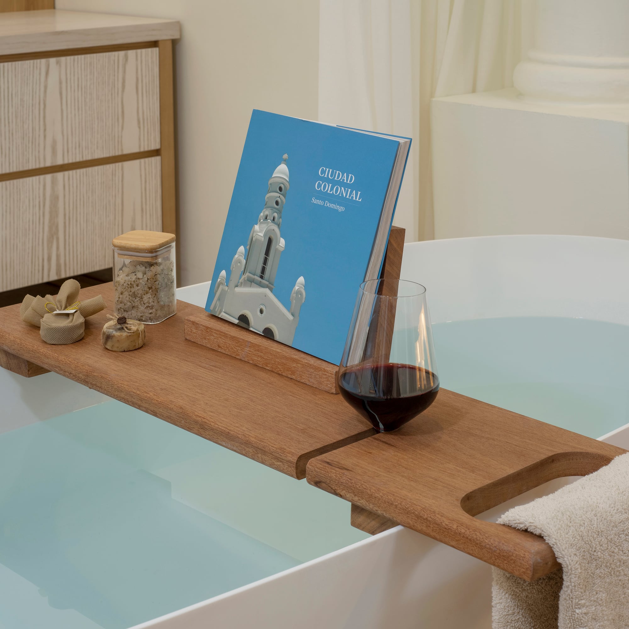 a bathtub with a book and a glass of wine