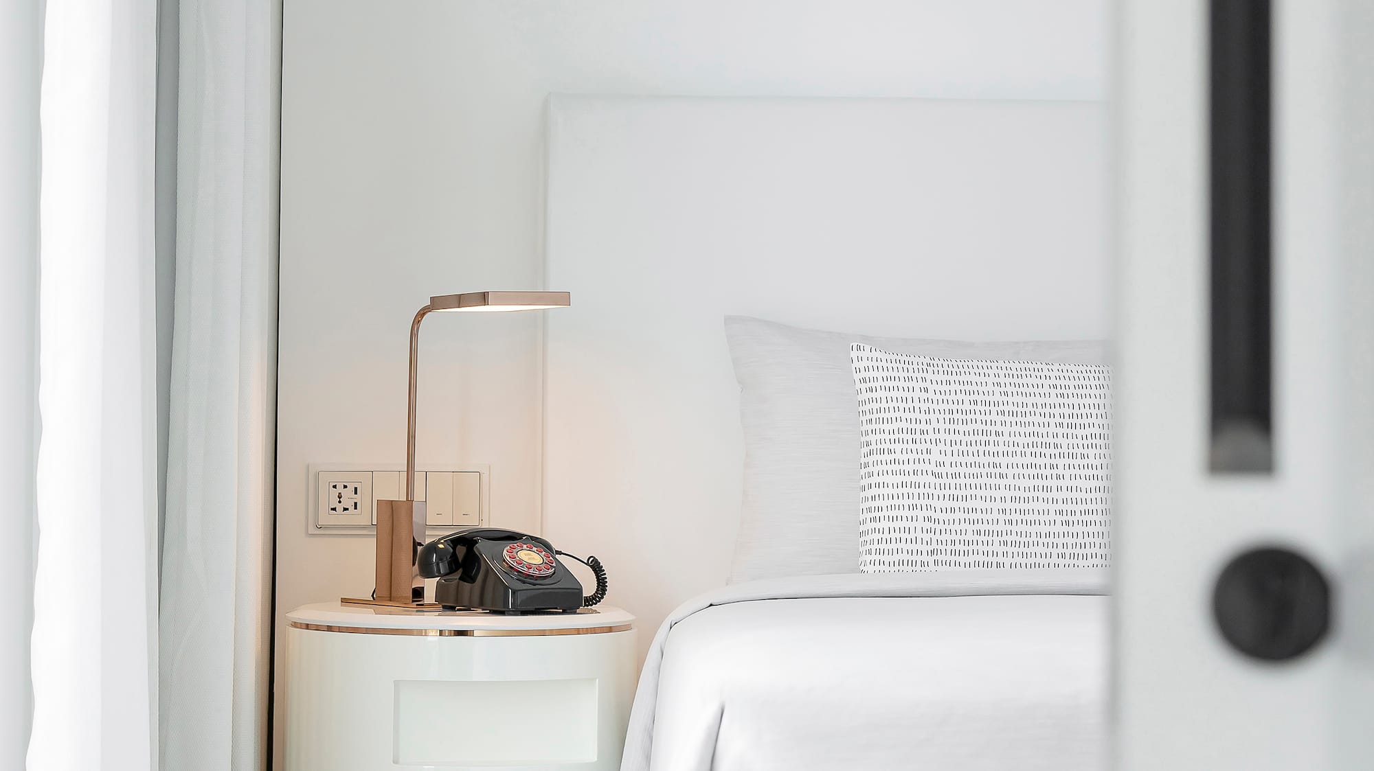 a bed with a telephone on the side table