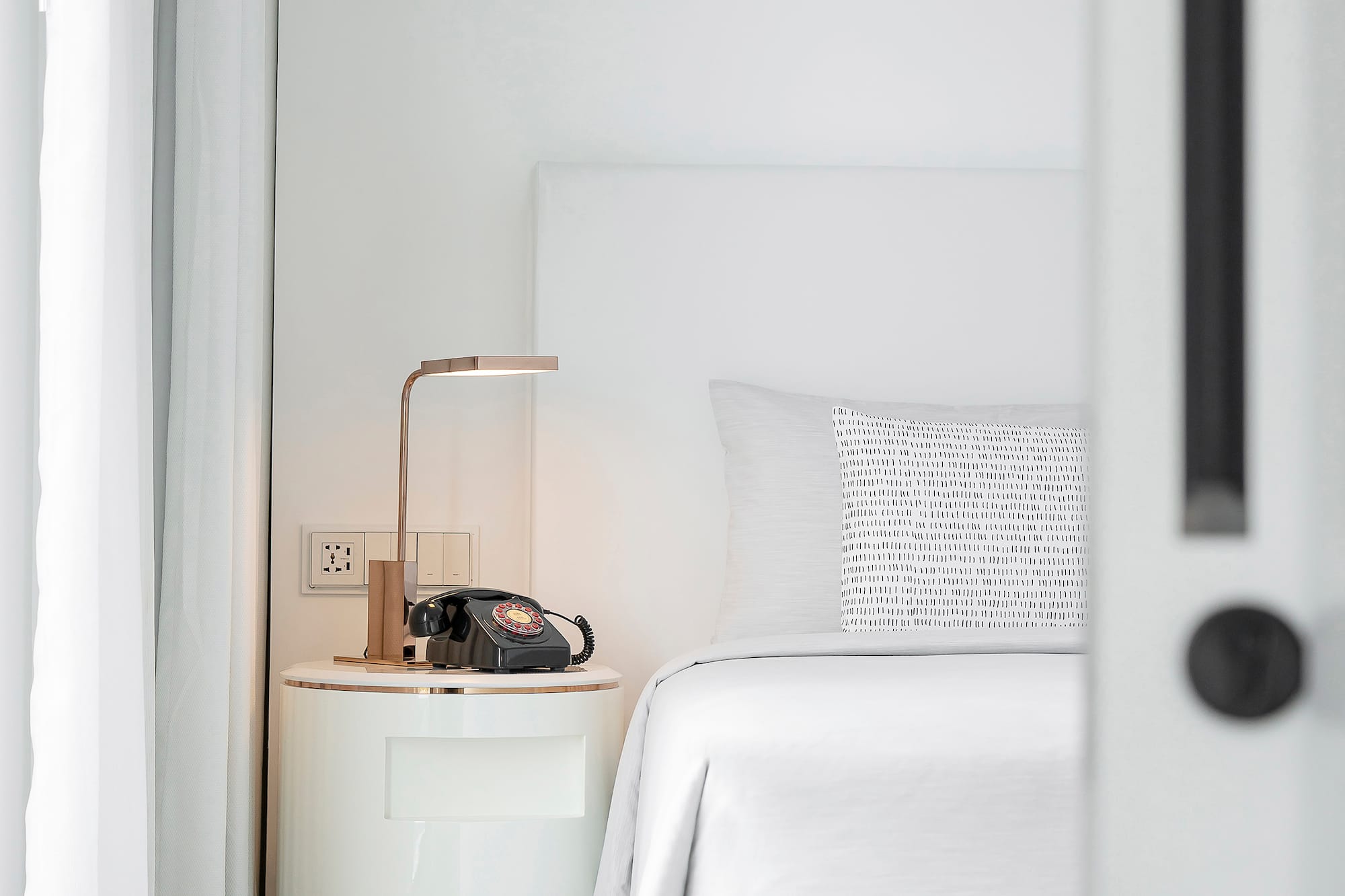 a bed with a telephone on the side table