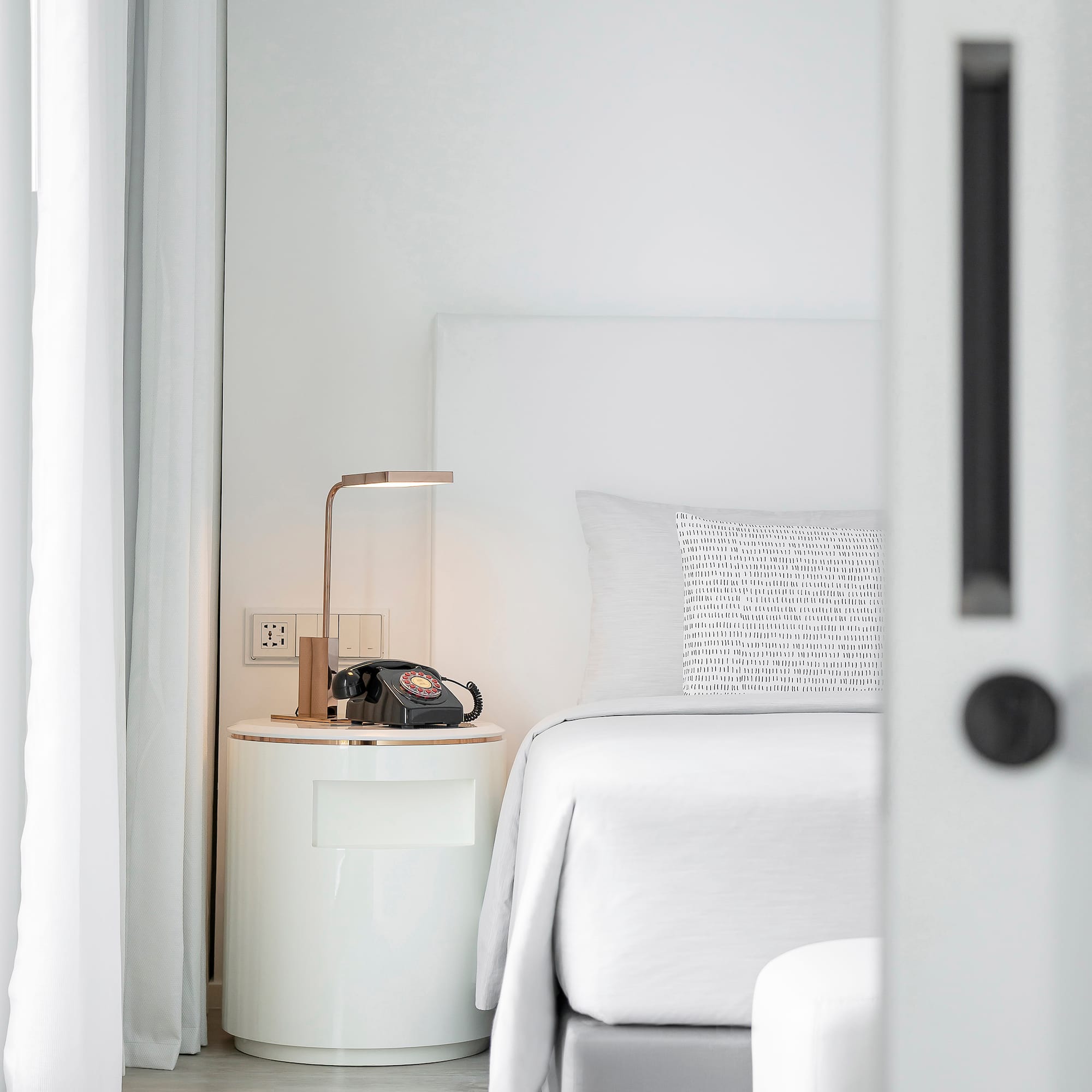 a bed with a telephone on the side table