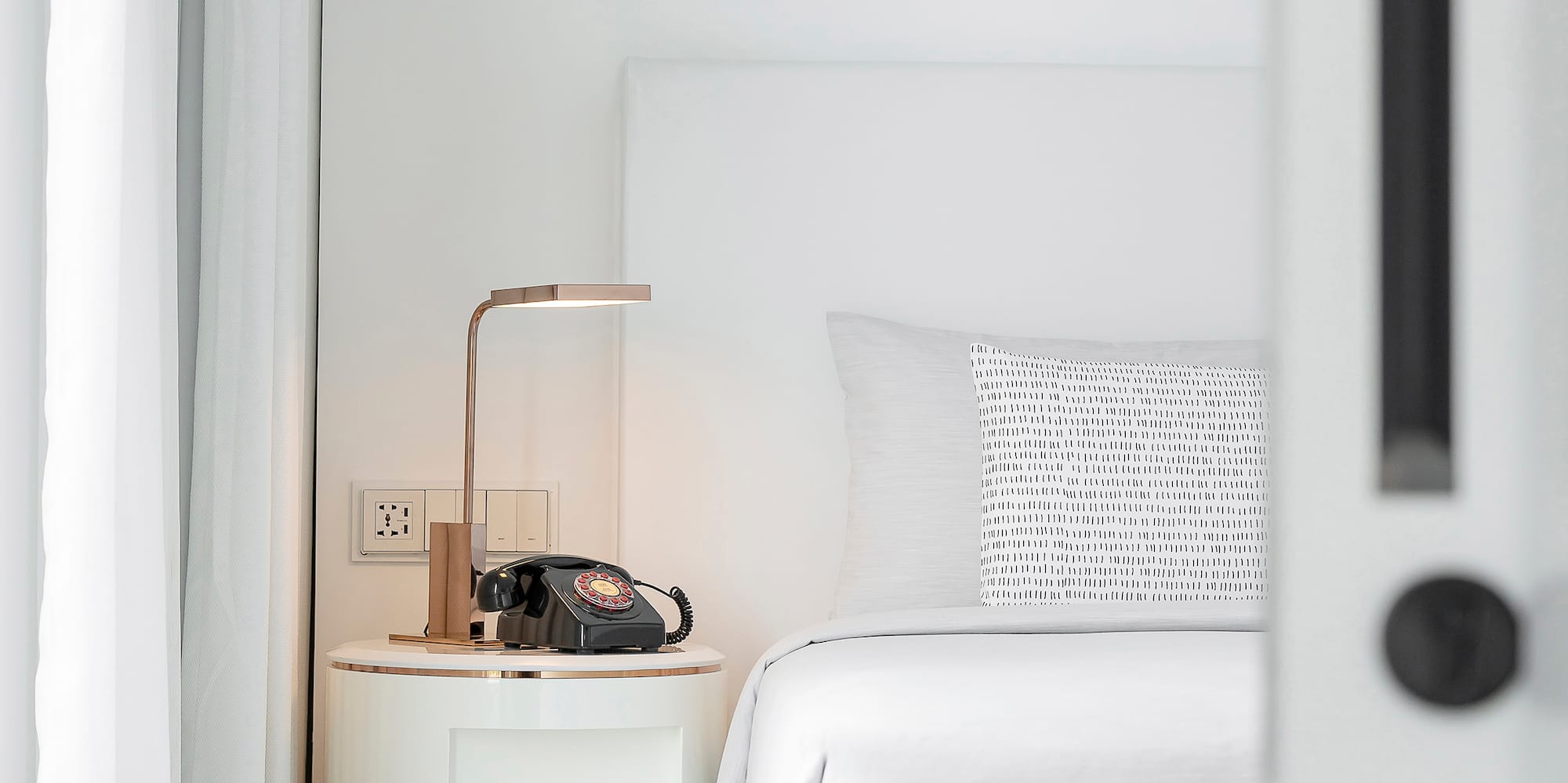 a bed with a telephone on the side table