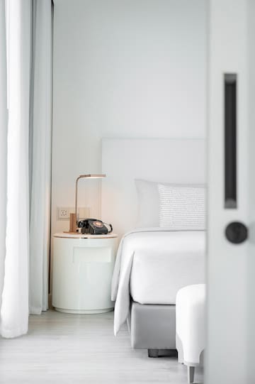 a bed with a telephone on the side table