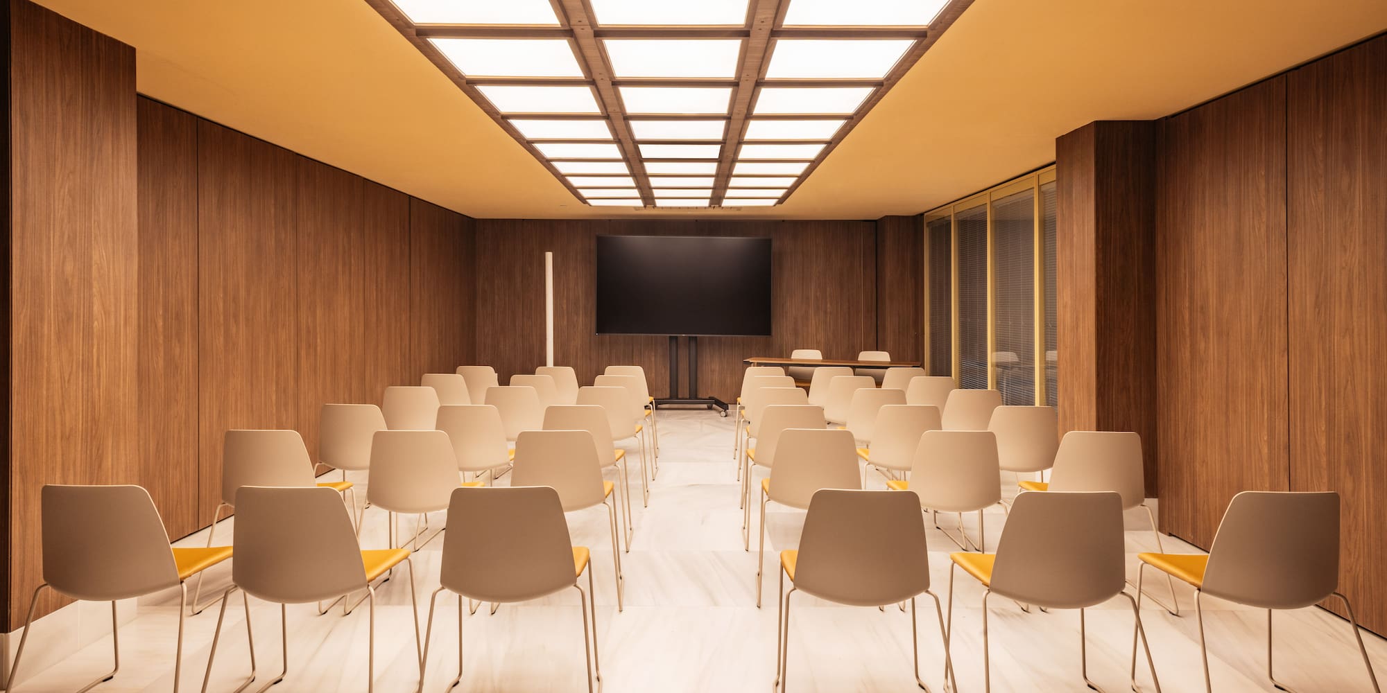 a room with many chairs and a screen