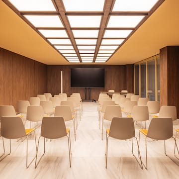 a room with many chairs and a screen