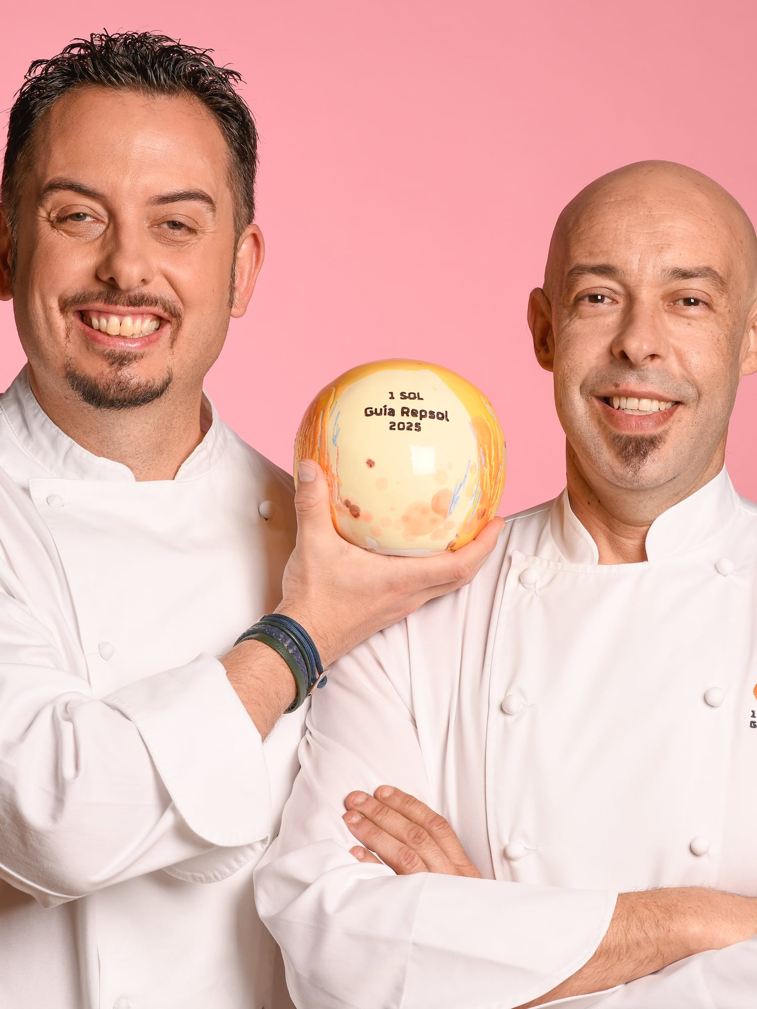 two men in chef uniforms holding a ball