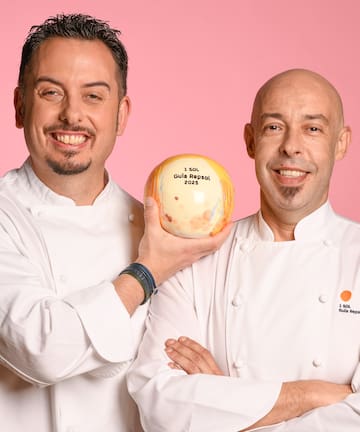 two men in chef uniforms holding a ball