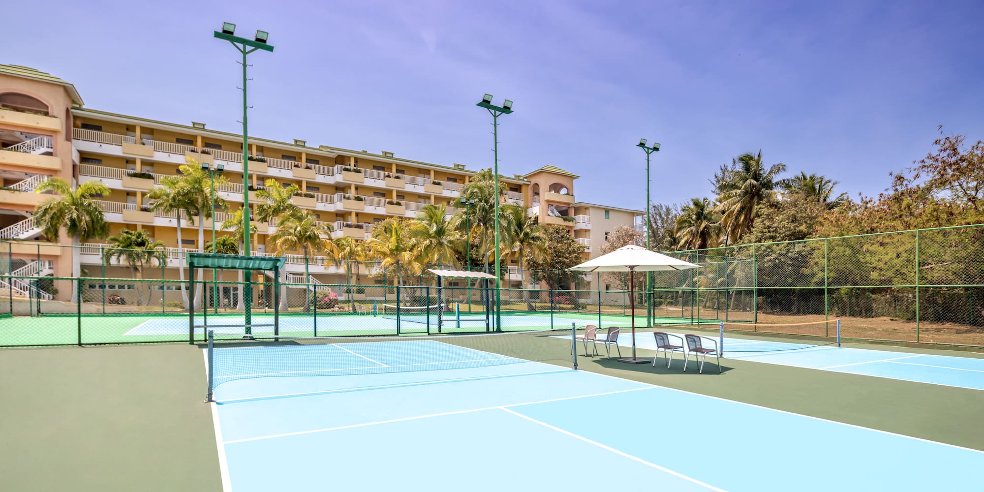 a tennis court with a large building in the background