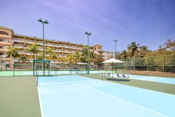 a tennis court with a large building in the background