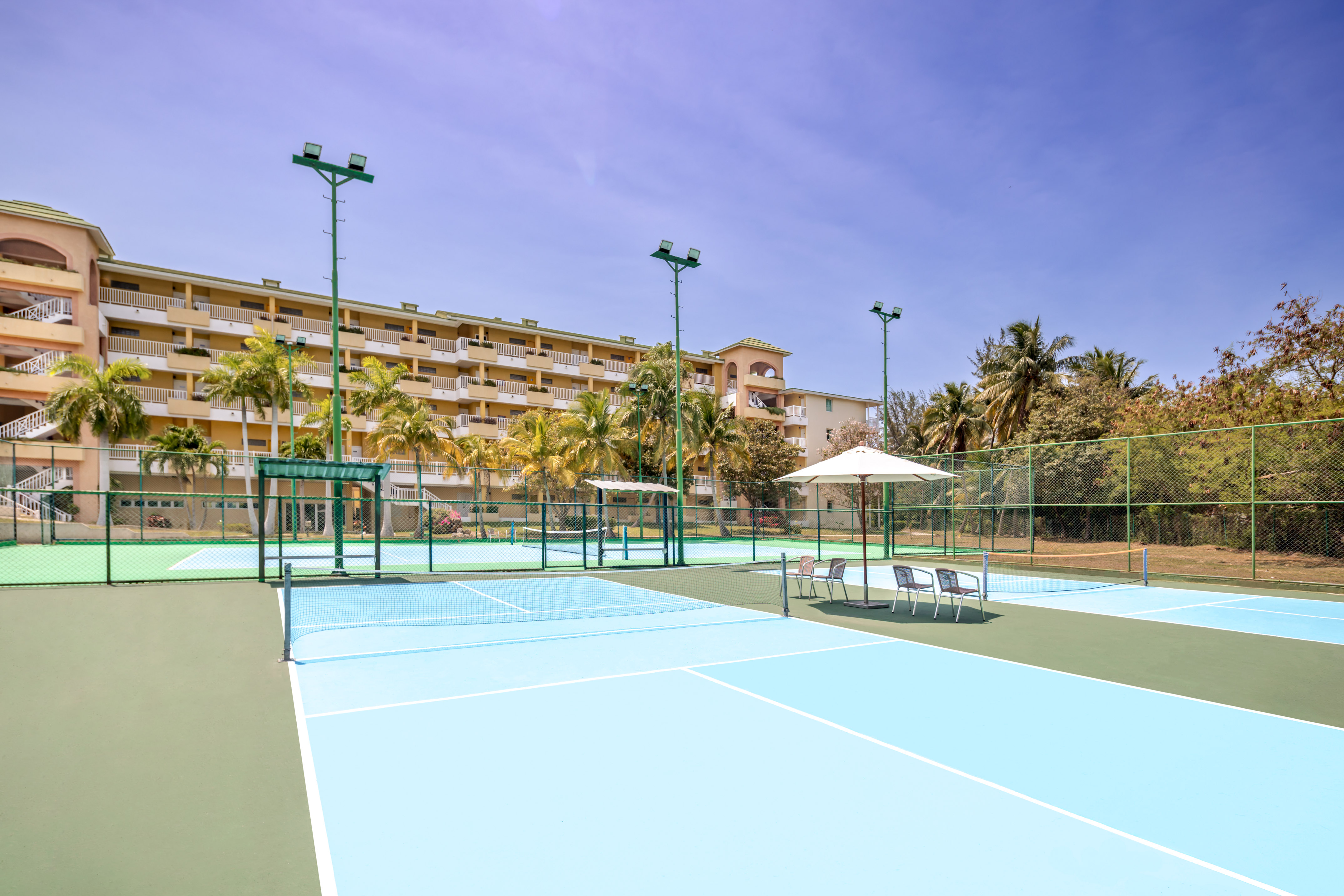 a tennis court with a large building in the background