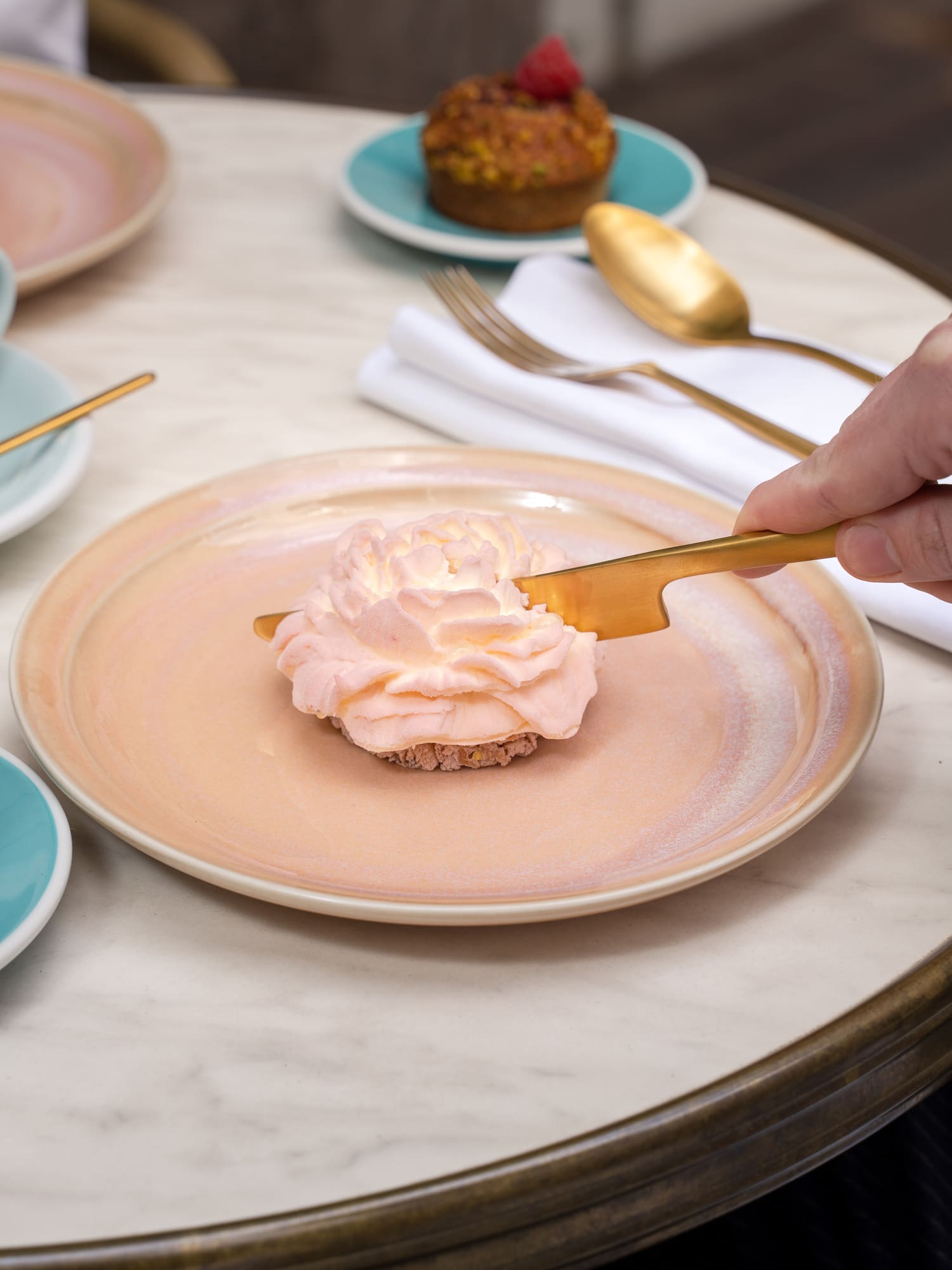 a person holding a knife over a dessert on a plate