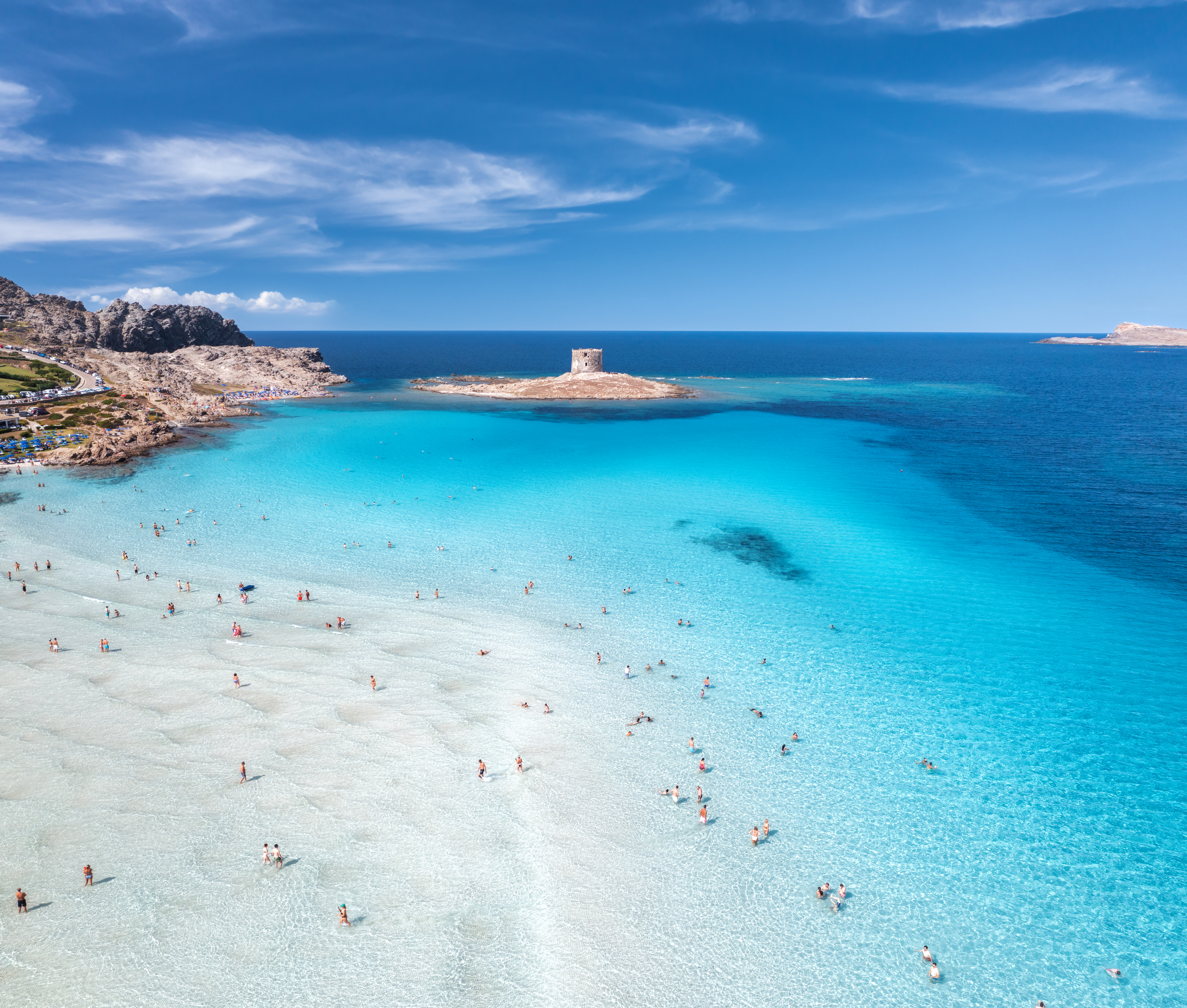 a beach with people swimming in the water