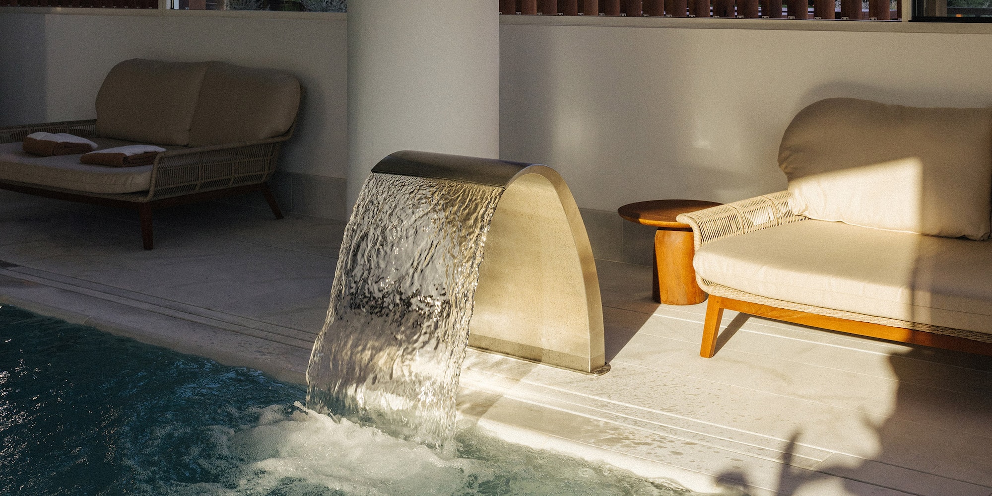 a pool with a waterfall and couches