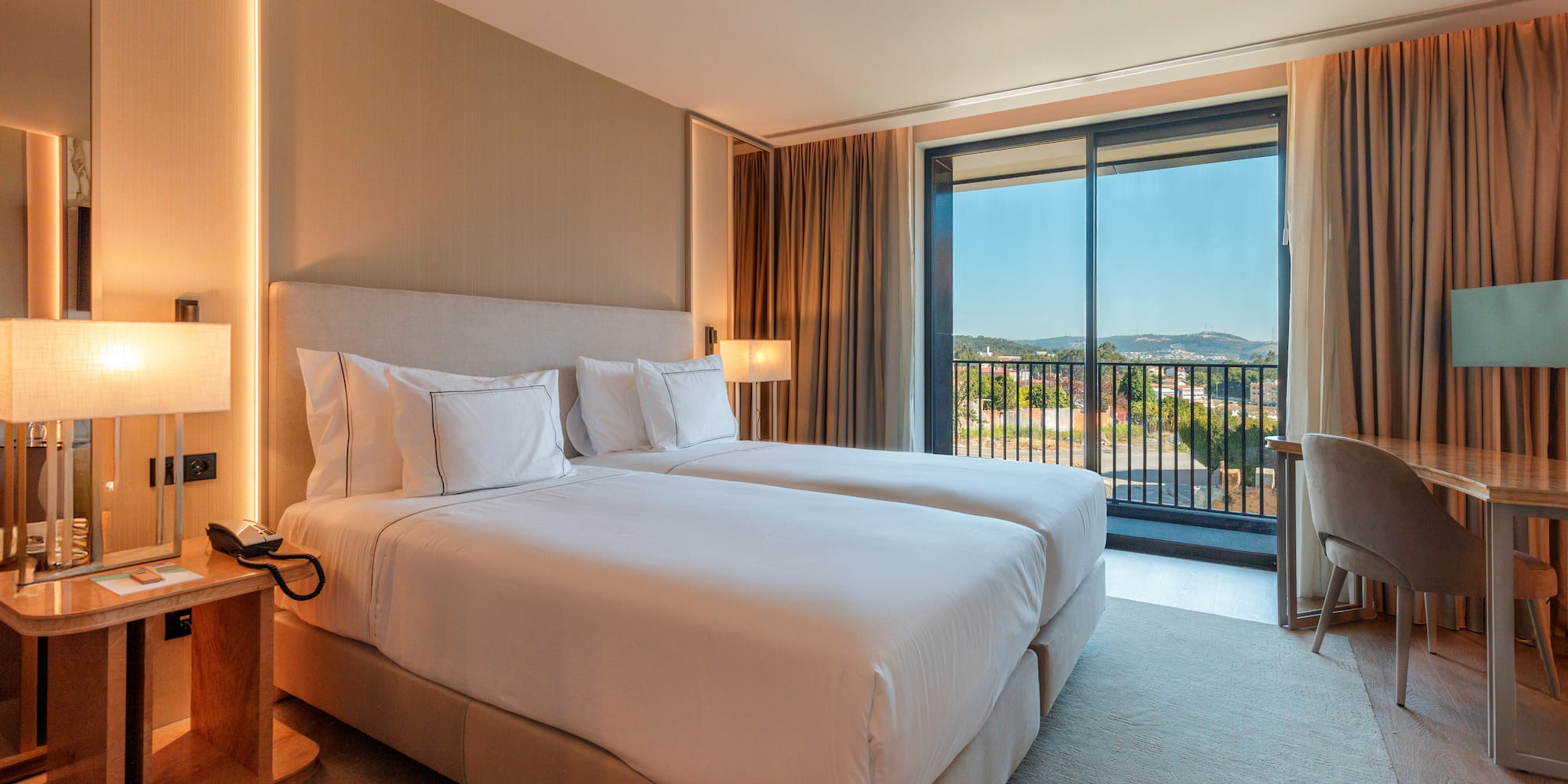 a hotel room with two beds and a balcony