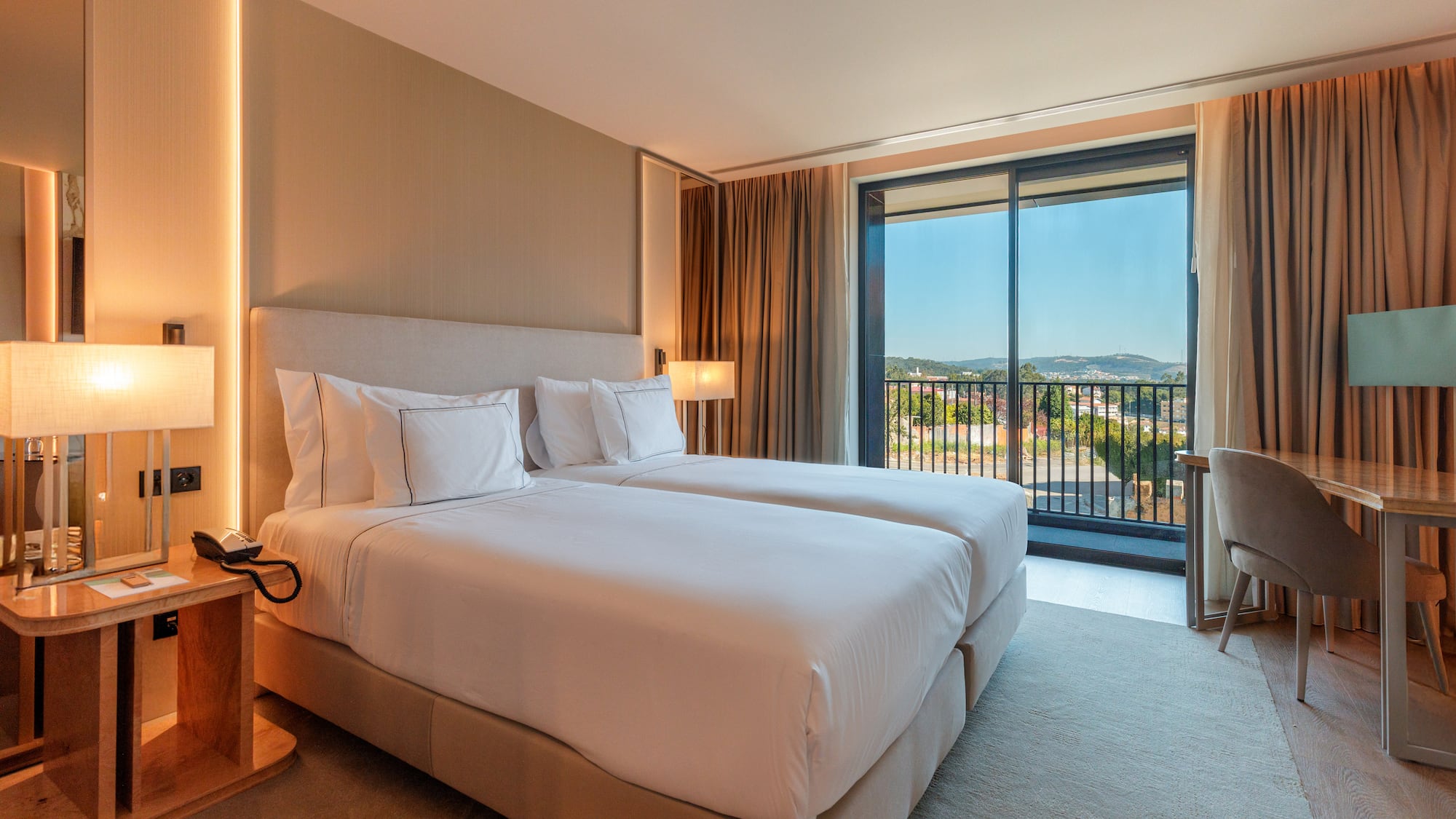 a hotel room with two beds and a balcony
