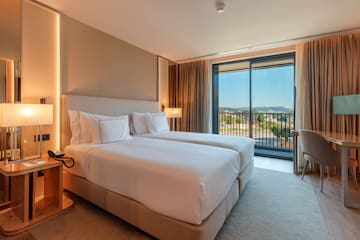 a hotel room with two beds and a balcony