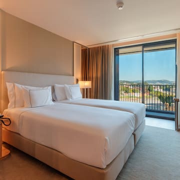 a hotel room with two beds and a balcony